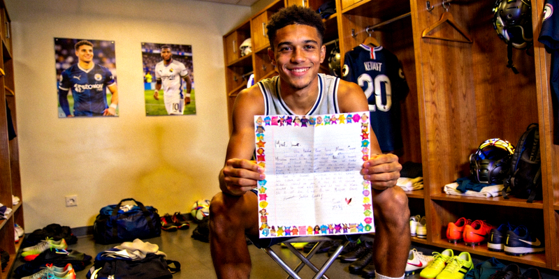 新生代球星在更衣室内阅读球迷来信的温馨场景